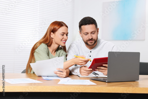 Couple calculating taxes at table in room