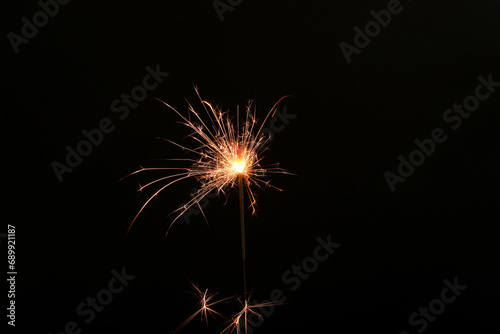 Burning sparkler stick on black background  space for text