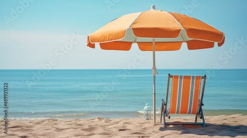 A beach chair and an umbrella on the beach.
