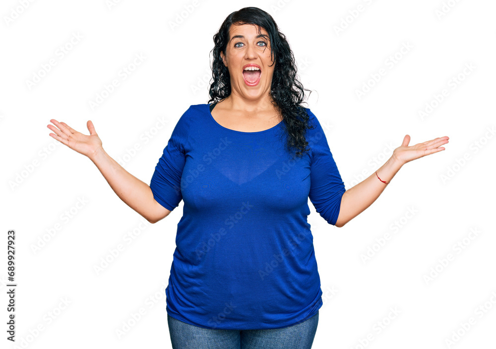 Plus size brunette woman wearing casual clothes celebrating victory with happy smile and winner expression with raised hands Plus size brunette woman wearing casual clothes celebrating victory with happy smile and winner expression with raised hands