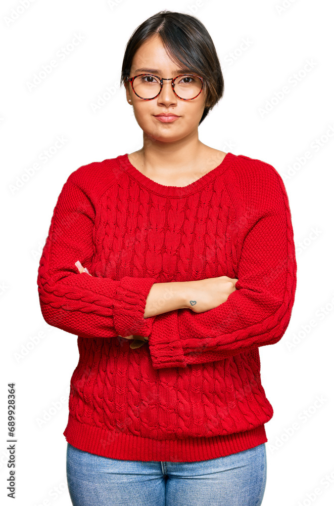Young beautiful hispanic woman with short hair wearing casual sweater and glasses skeptic and nervous, disapproving expression on face with crossed arms. negative person. Young beautiful hispanic woman with short hair wearing casual sweater and glasses skeptic and nervous, disapproving expression on face with crossed arms. negative person.