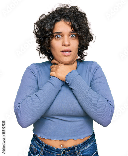 Young hispanic woman with curly hair wearing casual clothes shouting and suffocate because painful strangle. health problem. asphyxiate and suicide concept.
