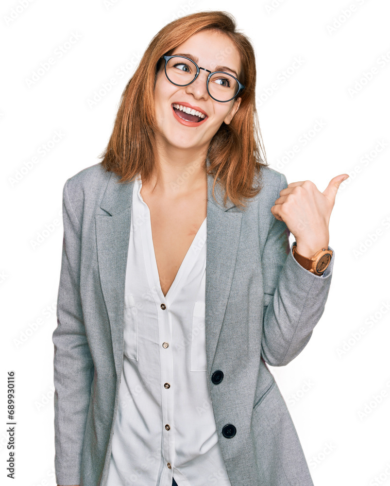 Young caucasian woman wearing business style and glasses smiling with happy face looking and pointing to the side with thumb up. Young caucasian woman wearing business style and glasses smiling with happy face looking and pointing to the side with thumb up.