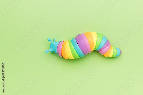 A colorful toy caterpillar crawling on a green background.