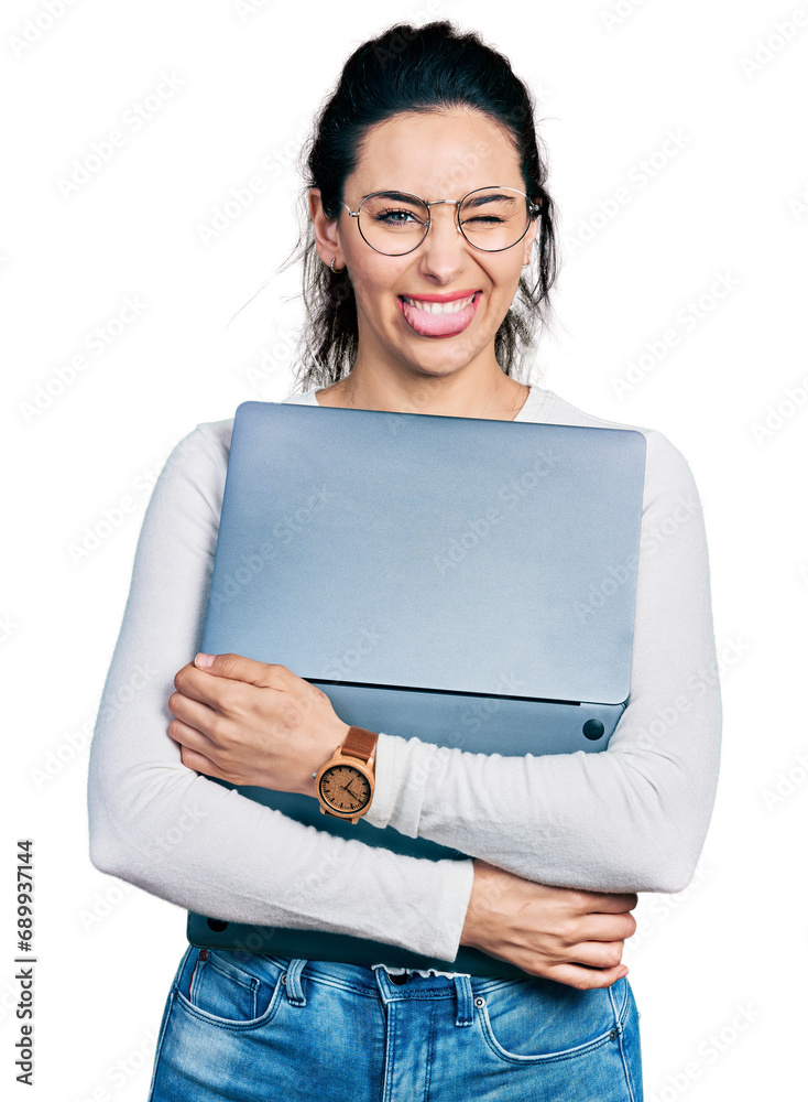 Young hispanic woman working using computer laptop sticking tongue out happy with funny expression. Young hispanic woman working using computer laptop sticking tongue out happy with funny expression.