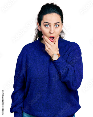 Young hispanic woman wearing casual clothes looking fascinated with disbelief, surprise and amazed expression with hands on chin