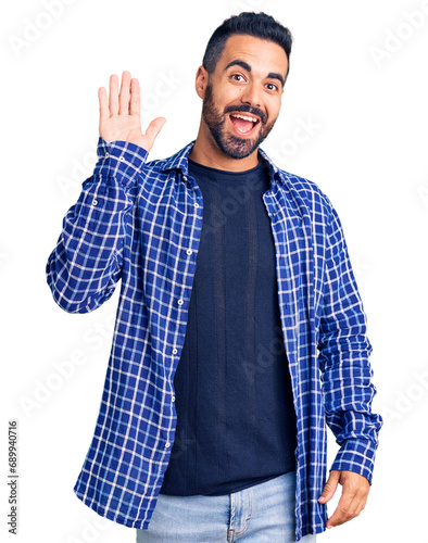 Canvas Print Young hispanic man wearing casual clothes waiving saying hello happy and smiling