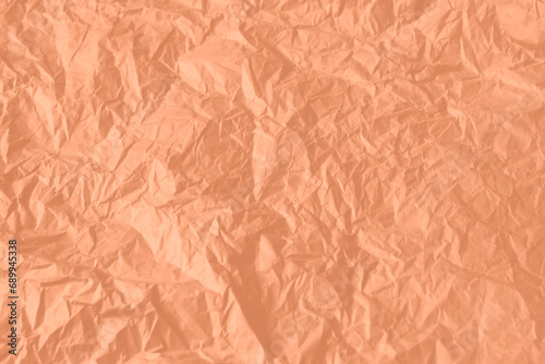 Crumpled paper Peach Fuzz color of the year 2024. Texture crumpled paper for your design. Copy space.
