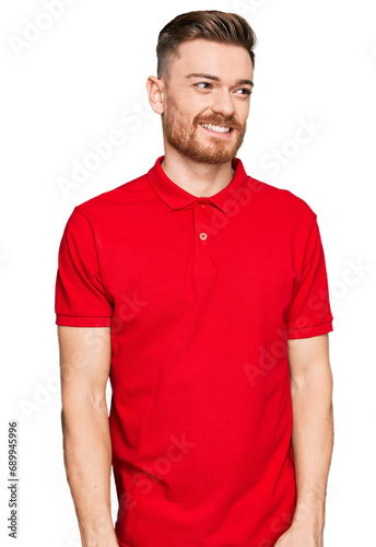 Young redhead man wearing casual clothes looking away to side with smile on face, natural expression. laughing confident.