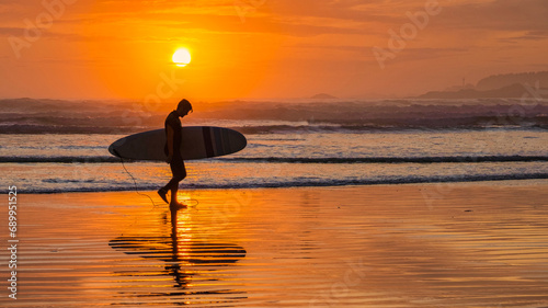 Tofino Beach Vancouver Island Pacific rim coast during sunset, surfers with surfboard during sunset at the beach of Tofino, surfers silhouette Canada Vancouver Island Tofino Long beach