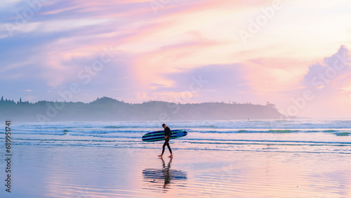 Tofino Beach Vancouver Island Pacific rim coast during sunset, surfers with surfboard during sunset at the beach, Canada Vancouver Island Tofino Long beach