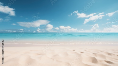 A tranquil sandy beach meets clear, shallow waters under a vast blue sky dotted with clouds, conveying peace and serenity. © DigitalArt