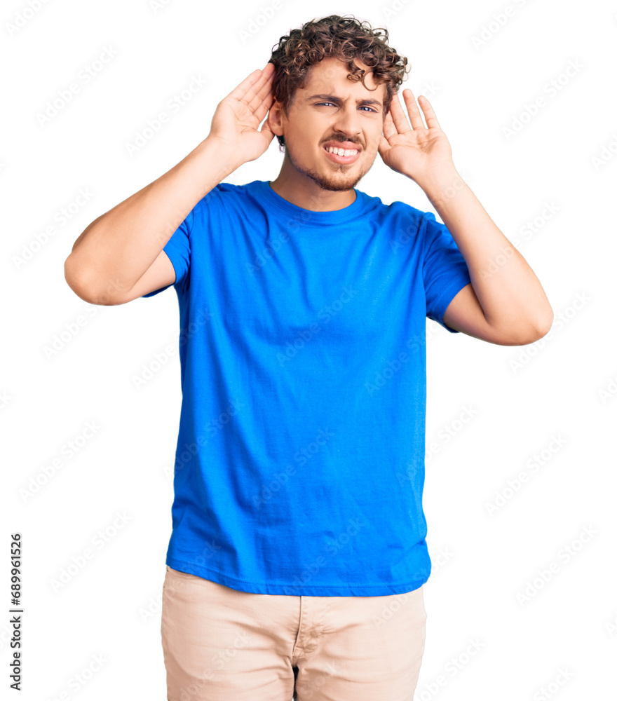 Fototapeta premium Young handsome man with curly hair wearing casual clothes trying to hear both hands on ear gesture, curious for gossip. hearing problem, deaf