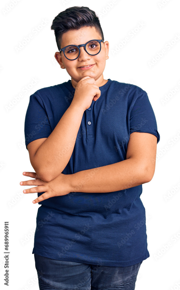 Little boy kid wearing casual clothes and glasses looking confident at the camera with smile with crossed arms and hand raised on chin. thinking positive. Little boy kid wearing casual clothes and glasses looking confident at the camera with smile with crossed arms and hand raised on chin. thinking positive.