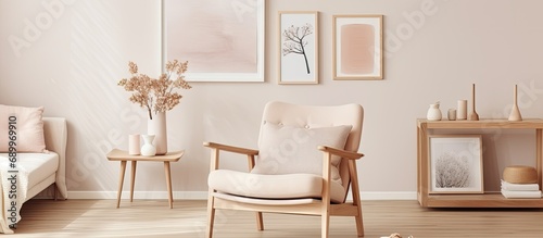 Cream-colored armchair in Scandinavian living room with gallery of posters on beige wall. photo