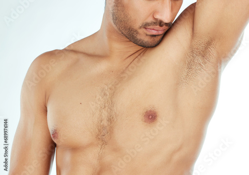 Body, closeup and man smelling armpit in studio for wellness, hygiene or control on white background. Underarm, care or guy model with sweat, scent or odor check after shower, cleaning or grooming photo