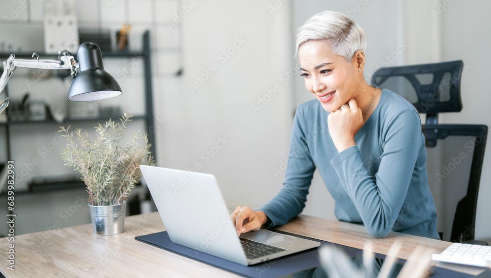 Portrait confident female designer working on laptop computer at home office. Portrait confident female designer working on laptop computer at home office.