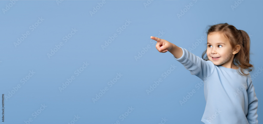 Little girl on a blue background points with her finger Little girl on a blue background points with her finger