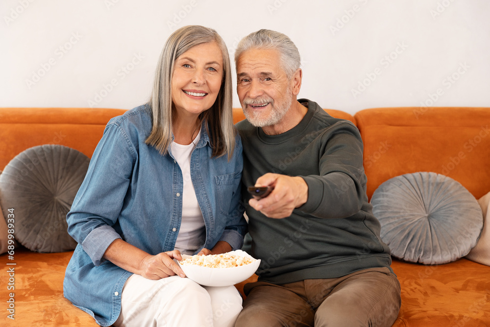Couple watching funny movie on tv popcorn while chilling on couch. Couple watching funny movie on tv popcorn while chilling on couch.