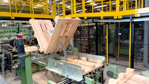 Real-time tumbler machine rotating wood timber for industrial Europallets automated manufacturing. photo