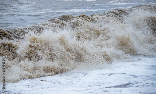 Large waves hit the shore. Storm at sea, storm warning on the coast. Thunderclouds and large sea waves during a storm.