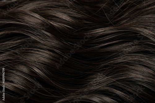 Dark curly long hair in close-up. A wave of hair as a background