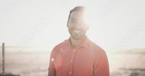 Happy, face and asian man laughing at beach with freedom, joy and positive energy, mindset or attitude outdoor. Adventure, portrait and Japanese male person at the ocean with fresh air at sunset photo