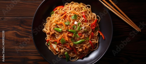 Hakka Noodles is a popular Indo-Chinese recipe. Schezwan Noodles with vegetables. Top view. photo