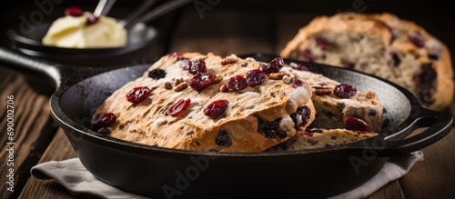 St. Patrick's Day recipe idea: Irish soda bread cooked in a cast iron pan with cranberries, pecans, and served with Irish butter. photo