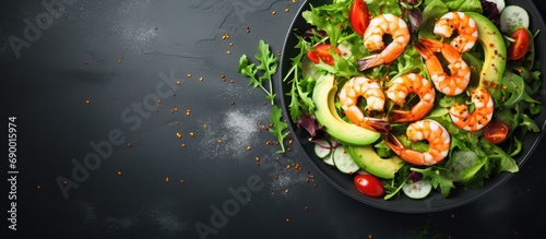 Top-down view of a nutritious salad with avocado and shrimps.