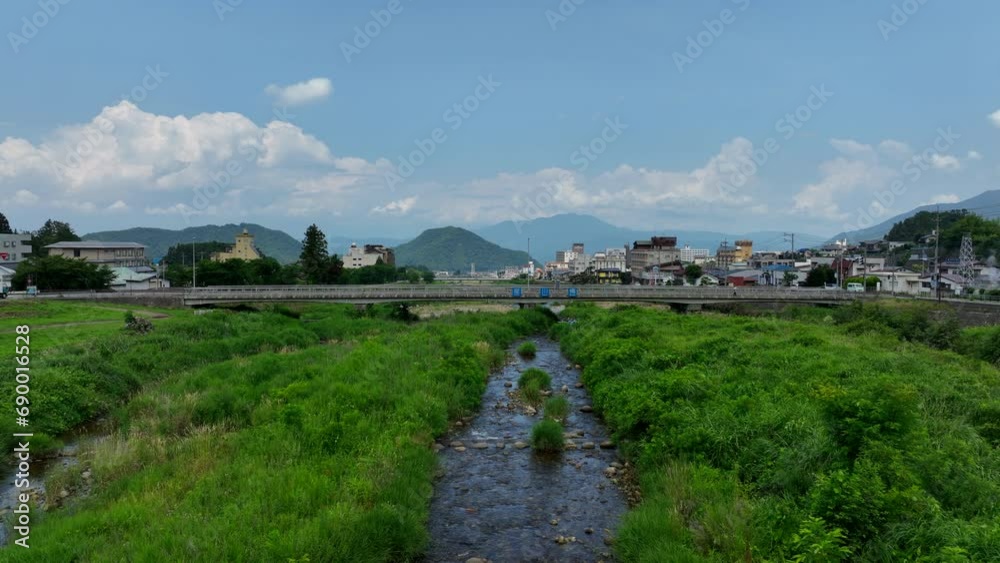 Aerial view low over the Yomase river, sunny, summer day in Yamanochi, Japan Aerial view low over the Yomase river, sunny, summer day in Yamanochi, Japan