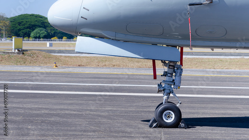 Close-up of front wheels of airplane with chock, Airplane parked at the airport, aircraft undercarriage. Detail of nose wheel.