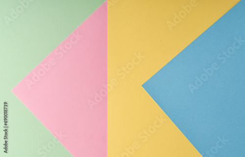 Multi colored abstract paper of pastel blue,pink,yellow,green colors palette, with geometric shape, flat lay.