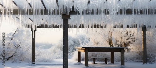 Pergola covered in ice and icicle after winter rain.