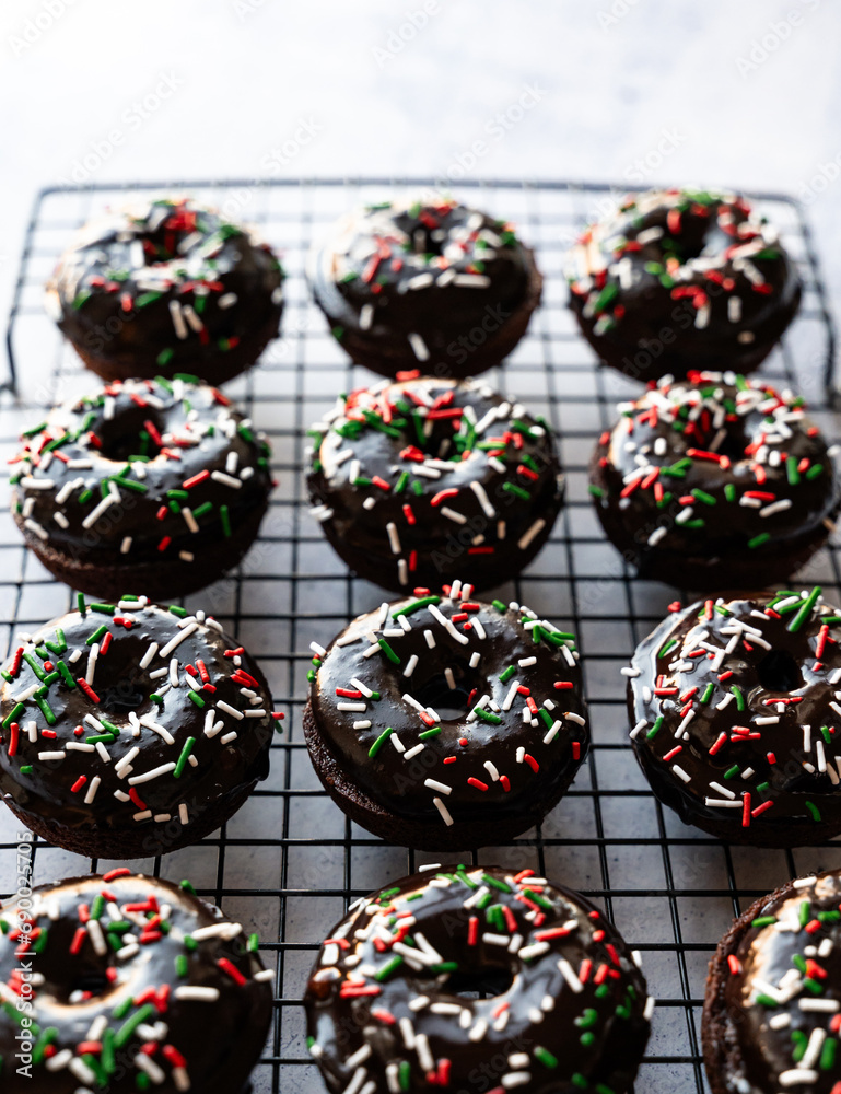 High angle close up of chocolate donuts with Christmas sprinkles.