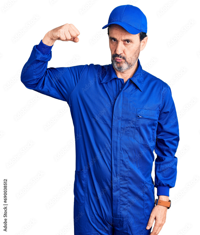 Middle age handsome man wearing mechanic uniform strong person showing arm muscle, confident and proud of power