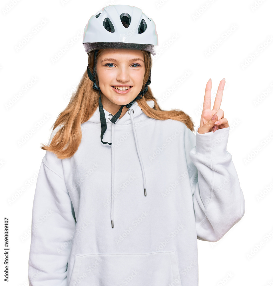 Beautiful young caucasian girl wearing bike helmet smiling with happy face winking at the camera doing victory sign. number two. Beautiful young caucasian girl wearing bike helmet smiling with happy face winking at the camera doing victory sign. number two.