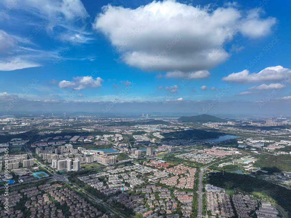 Aerial photography of green city, urban buildings, livable environment, blue sky and white clouds