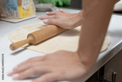 Girl rolling out dough in the kitchen