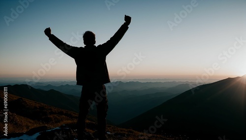 The man standing and arms up on top mountain.