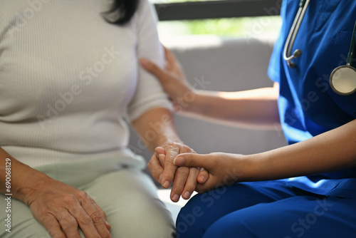 Cropped shot of doctor holding senior woman hand for hope and supporting. Elderly healthcare concept © Prathankarnpap