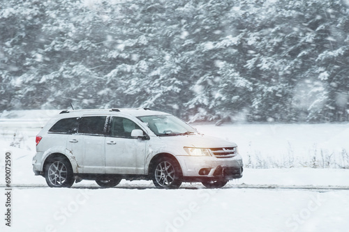 Driving on a snowy road to the winter resort. The photo captures a suv on a winter road with a lot of snow and ice. The road is snow and ice covered.
