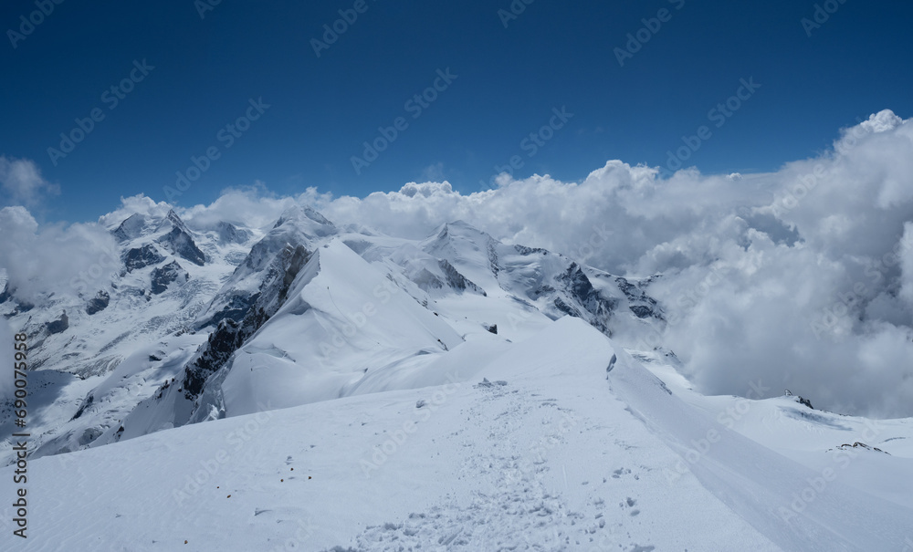 Zermatt, Switzerland - June 14th 2023: View from Breithorn peaks towards the surrounding mountains in clouds