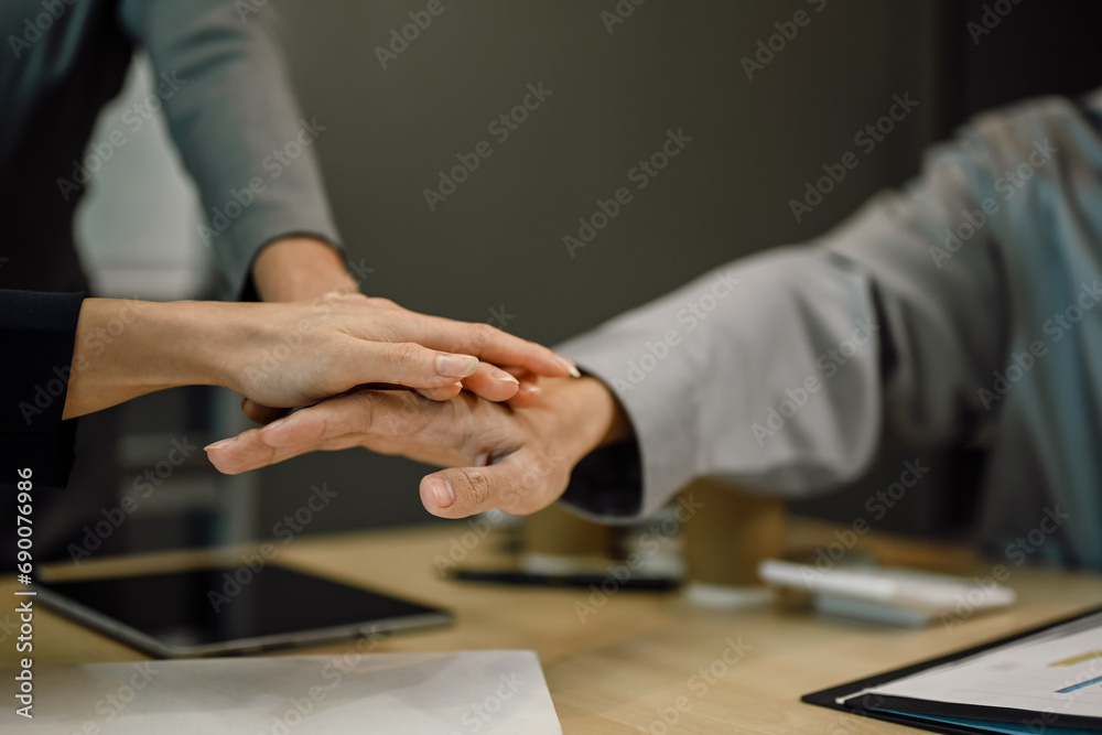 Cropped shot of business team stacking hands together at meeting table. Concept of corporate unity and solidarity Cropped shot of business team stacking hands together at meeting table. Concept of corporate unity and solidarity