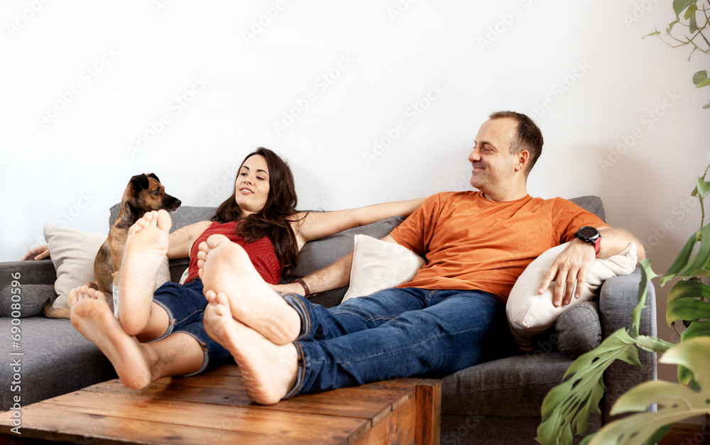 couple relaxing on the sofa at home with their pet couple relaxing on the sofa at home with their pet