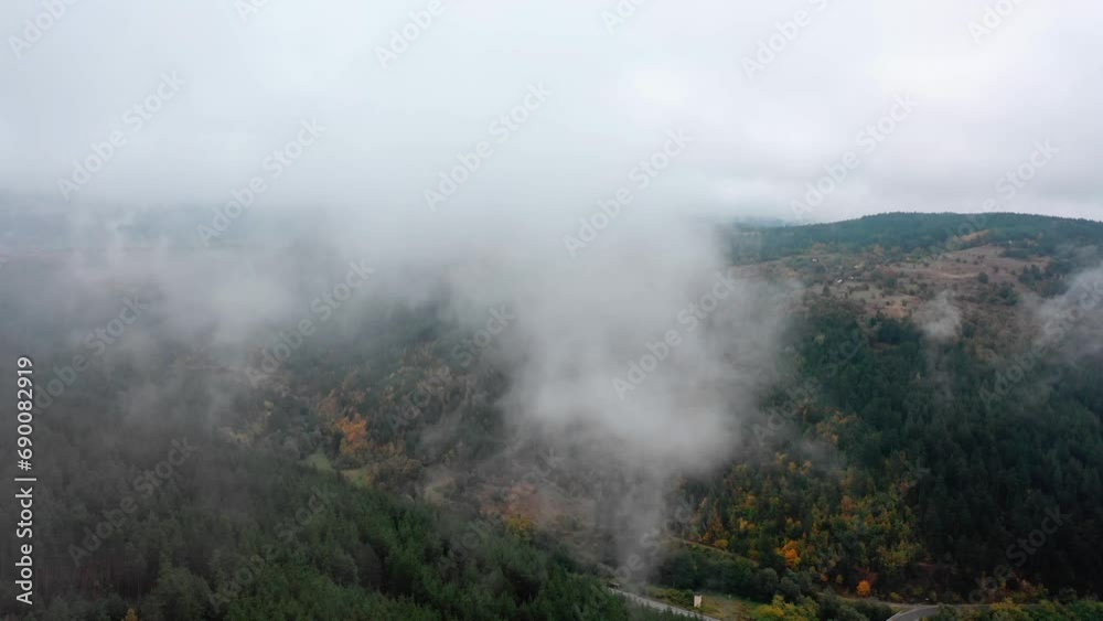 Aerial view of beautiful autumn trees on a foggy morning. Foggy clouds hover over a forest in the mountains Aerial view of beautiful autumn trees on a foggy morning. Foggy clouds hover over a forest in the mountains
