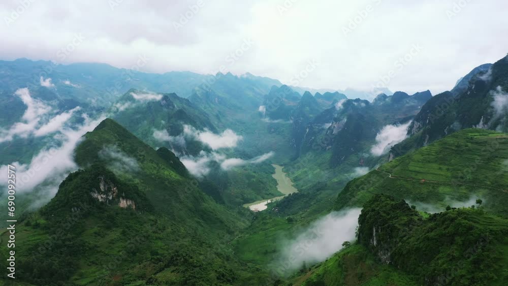Drone of green mountains, river and nature for travel background, eco tourism location and holiday. Aerial view of forest landscape, countryside road or highway and clouds in Vietnam, Ma Pi Leng Pass