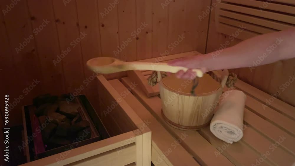 Frau mit Holzlöffel in der Sauna