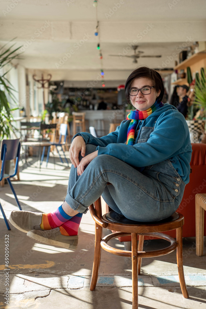 Portrait of a happy smiling neutral gender teenager in a living room with lots of indoor plants Portrait of a happy smiling neutral gender teenager in a living room with lots of indoor plants