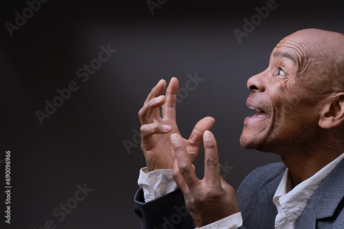 praying to god with hands together Caribbean man praying with black background with people stock photo photo